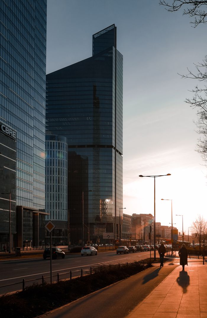 hero-img-02 Urban skyline of Warsaw with modern skyscrapers during sunset.